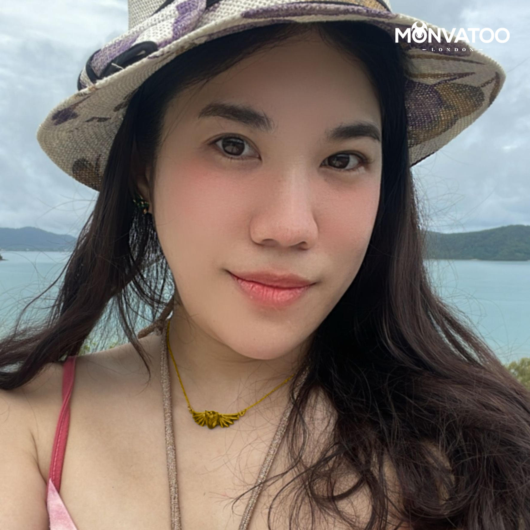 A girl is wearing the golden dragon necklace by MONVATOO London at the beach holiday trip